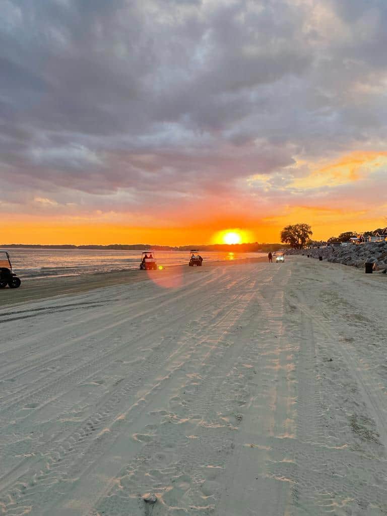 Golf carts on the beach at sunset